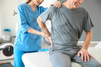 Physiotherapist working with mature patient in rehabilitation center�