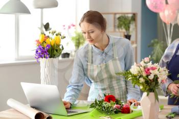 Florist working with laptop in shop�
