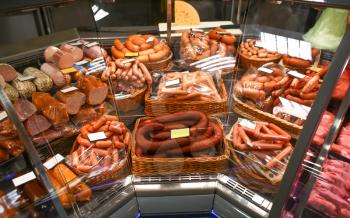 Refrigerated display case with fresh sausages in supermarket�