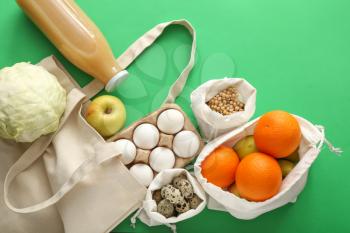 Cotton bags with fresh products on color background. Zero waste concept�