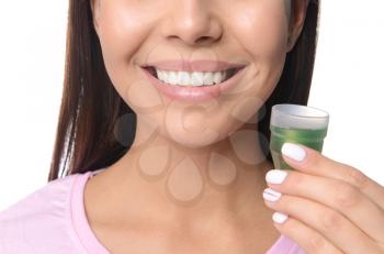 Woman with oral rinse on white background, closeup. Dental hygiene concept�