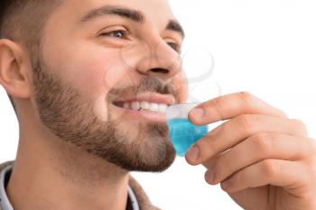 Handsome man with mouthwash on light background, closeup�