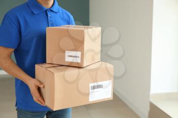 Delivery man with boxes indoors�
