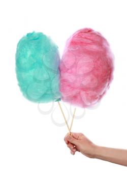 Female hand with different tasty cotton candies on white background�
