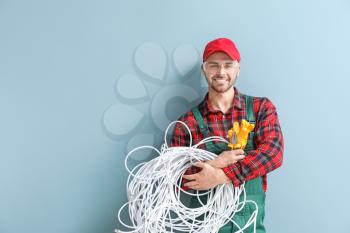 Male electrician on color background�