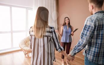 Real estate agent showing young couple a new house�