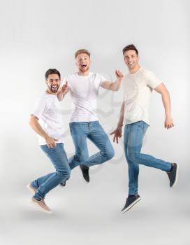 Jumping young men on light background�