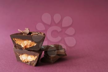 Tasty chocolate peanut butter cups on color background�
