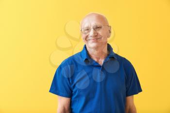Portrait of happy elderly man on color background�
