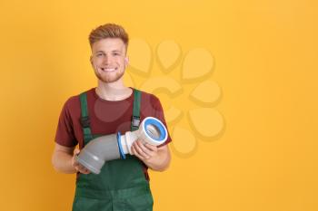 Handsome young plumber on color background�