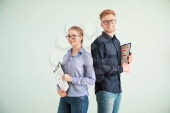 Portrait of male and female accountants on grey background�