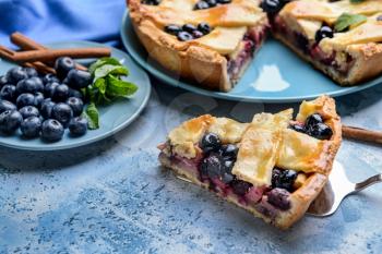 Tasty blueberry pie on color background�