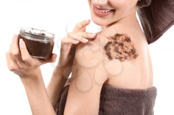Young woman with jar of body scrub on white background, closeup�