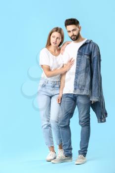 Stylish young couple in jeans clothes on color background�