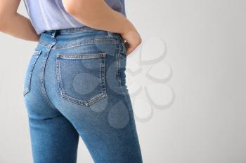 Young woman wearing stylish jeans pants on light background�