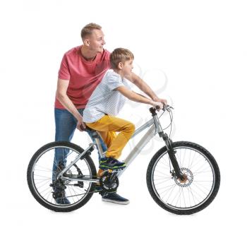 Father and his son with bicycle on white background�