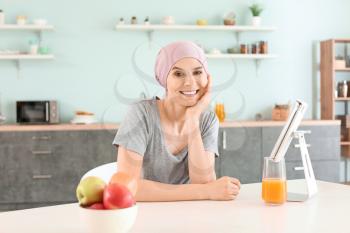 Woman after chemotherapy in kitchen at home�