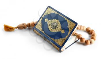 Muslim beads and Koran on white background�