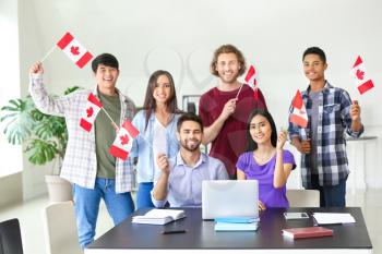 Group of students with Canadian flags in classroom�