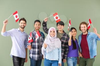 Group of students with Canadian flags on color background�