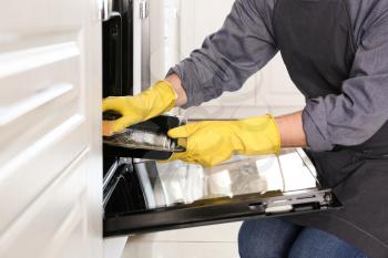 Man cleaning oven at home�