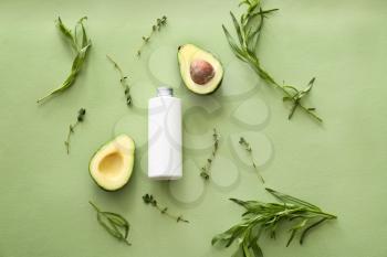 Bottle of shampoo, avocado and herbs on color background�