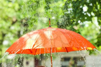 Bright umbrella outdoors on rainy day�