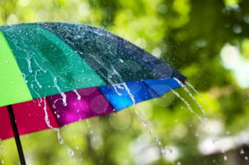 Colorful umbrella outdoors on rainy day�