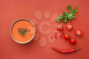 Bowl of tasty cream soup and ingredients on color background�