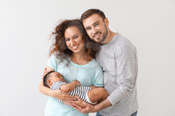 Portrait of happy interracial family on light background�