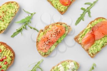 Different tasty avocado toasts on grey background�