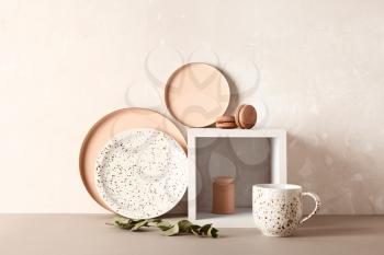 New tableware on table near grunge wall�