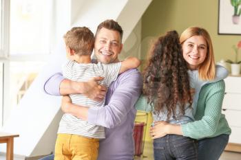 Happy couple with little adopted children at home�