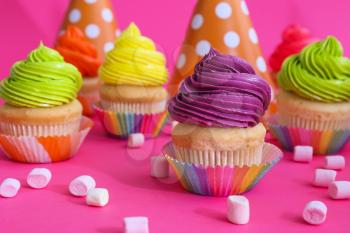 Sweet tasty cupcakes on color background�