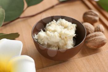 Bowl with shea butter on wooden board�
