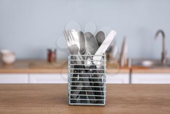 Clean cutlery in holder on table in kitchen�