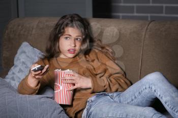 Emotional teenage girl watching TV at night�
