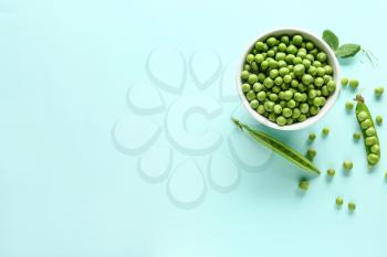 Bowl with tasty fresh peas on color background�