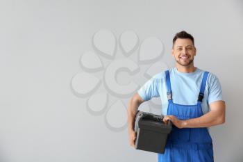 Portrait of handsome plumber with tools box on white background�
