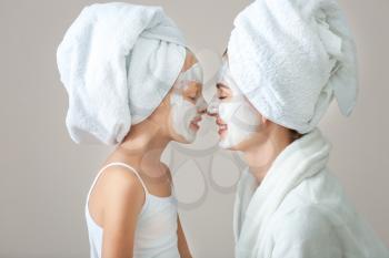 Portrait of mother with little daughter after shower on grey background�