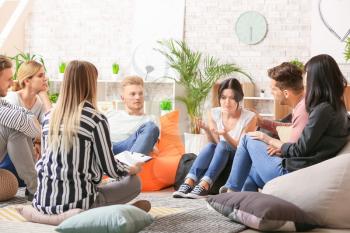 People calming woman at group therapy session�