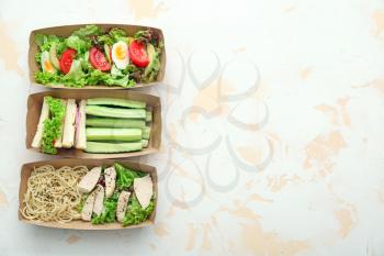 Paper boxes with delicious food on light background�