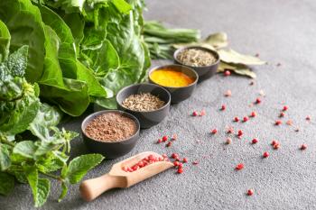 Different herbs and spices on grey background�