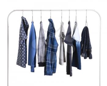 Stylish kid clothes hanging on rack against white background�