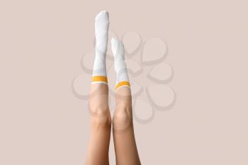 Legs of young woman in socks on light background�