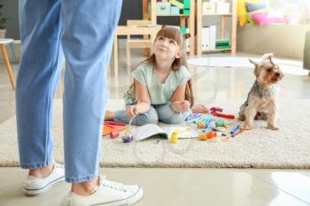 Mother scolding little girl for carpet messing up with paints�