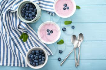Bowls with tasty blueberry and yogurt on table�