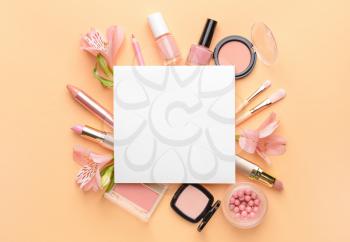 Set of decorative cosmetics and blank card on color background�