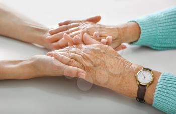 Hands of young and elderly woman on white background. Concept of support�