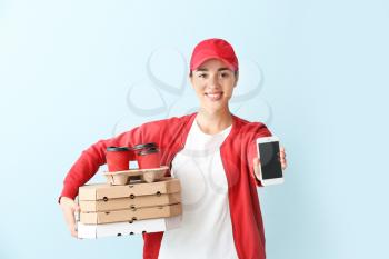 Female worker of food delivery service with mobile phone on color background�
